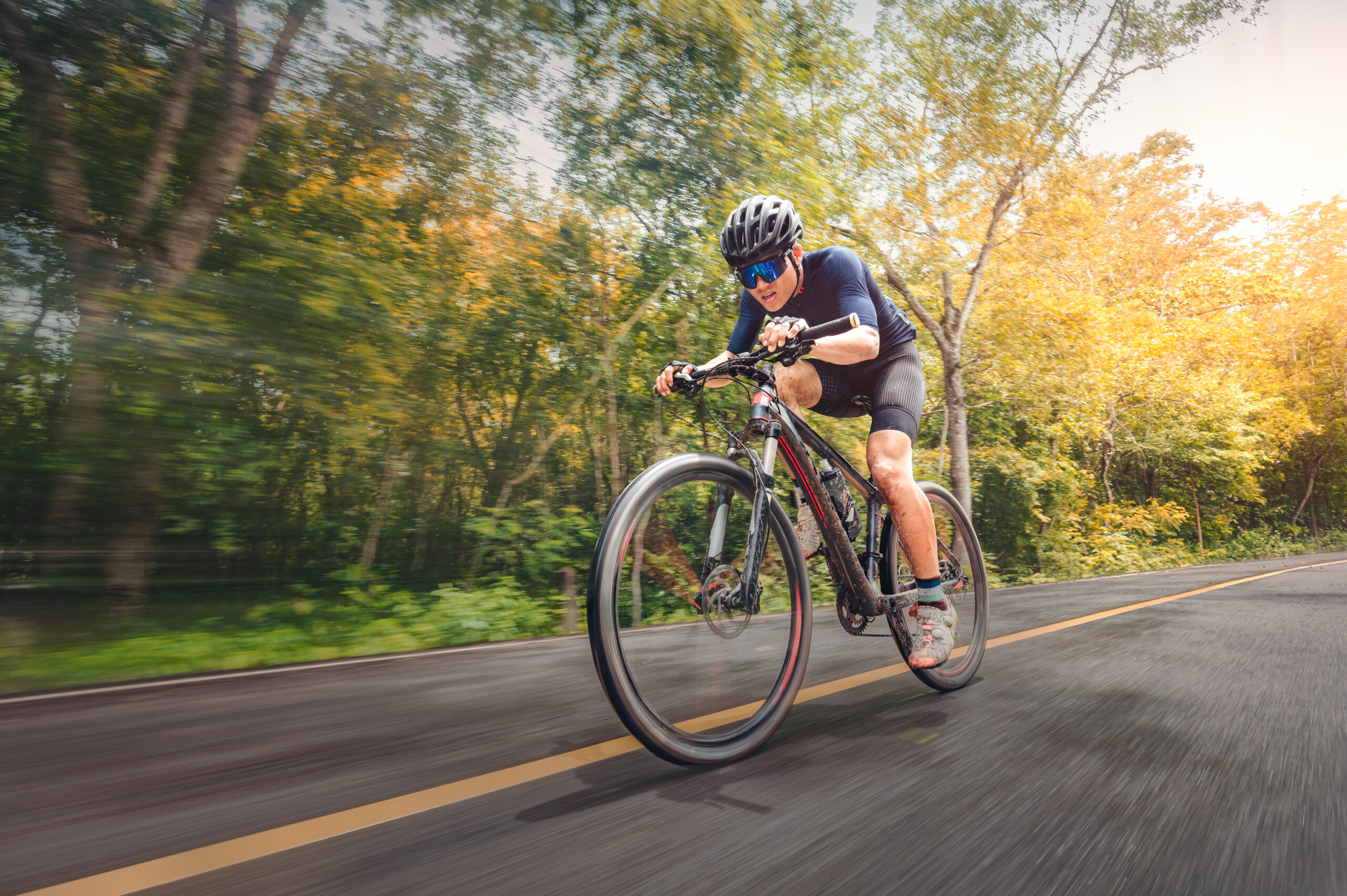 Cycling Mountain Bike Cycling MTB on the road shady with forest. Mountain biking athlete look at wild nature on mountain. Extreme Sport and MTB, mountain bike downhill of motion Concept. 