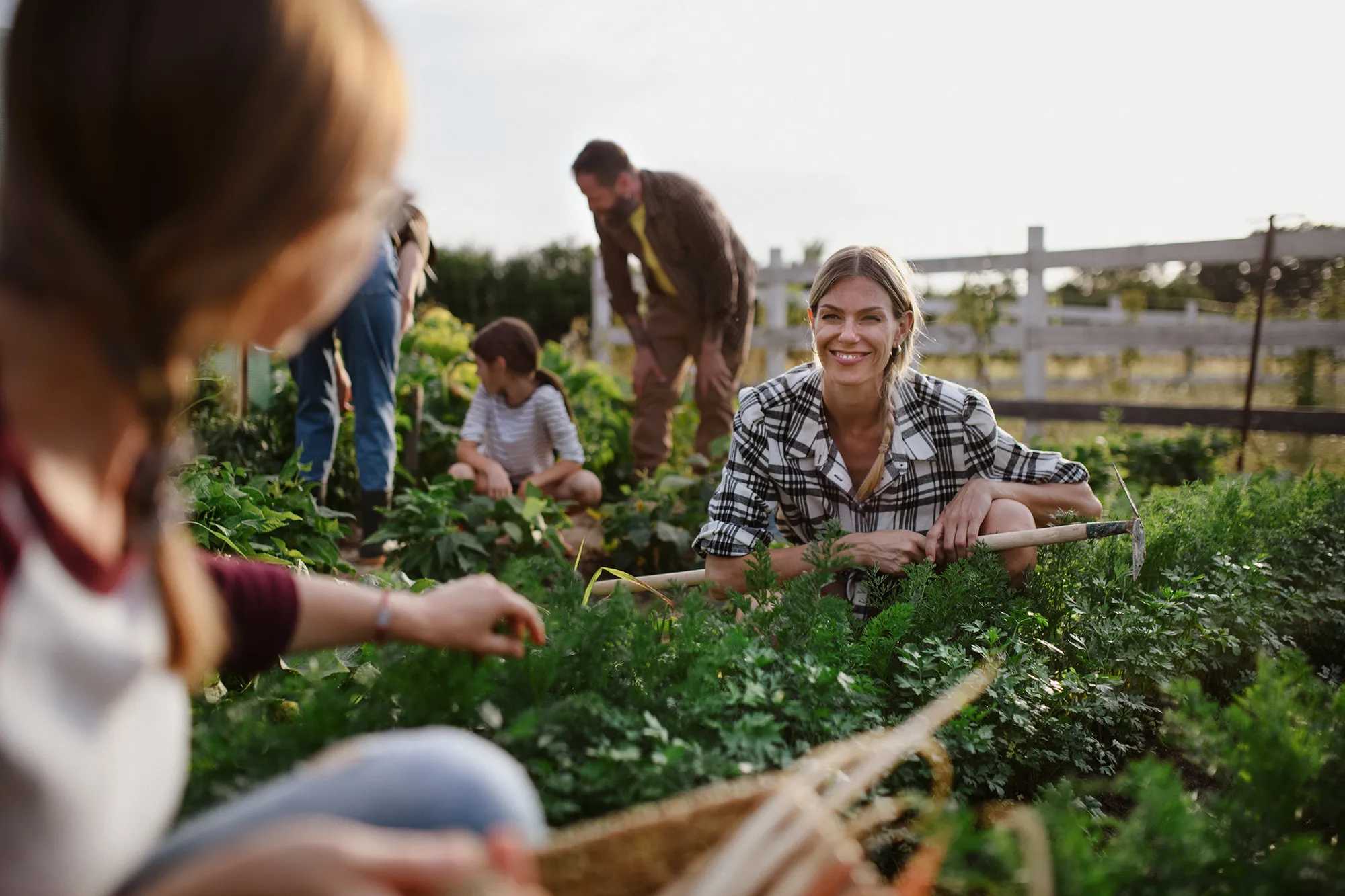 Happy farmers or gardeners working outdoors at community garden.