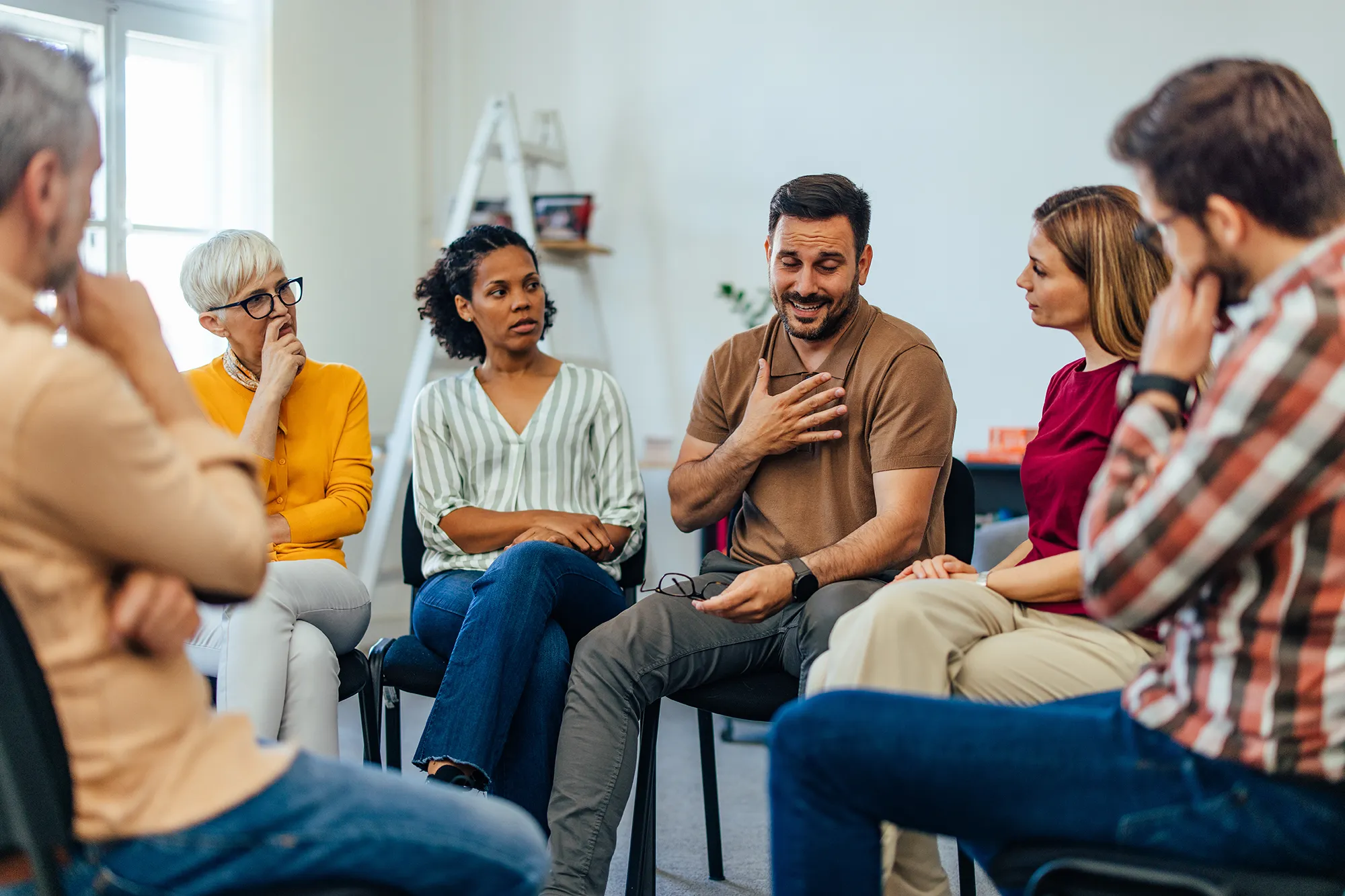 An upset man told his problems, looking emotional during the group therapy.
