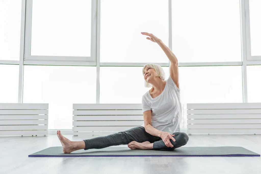 Joyful old woman undergoing morning exercises