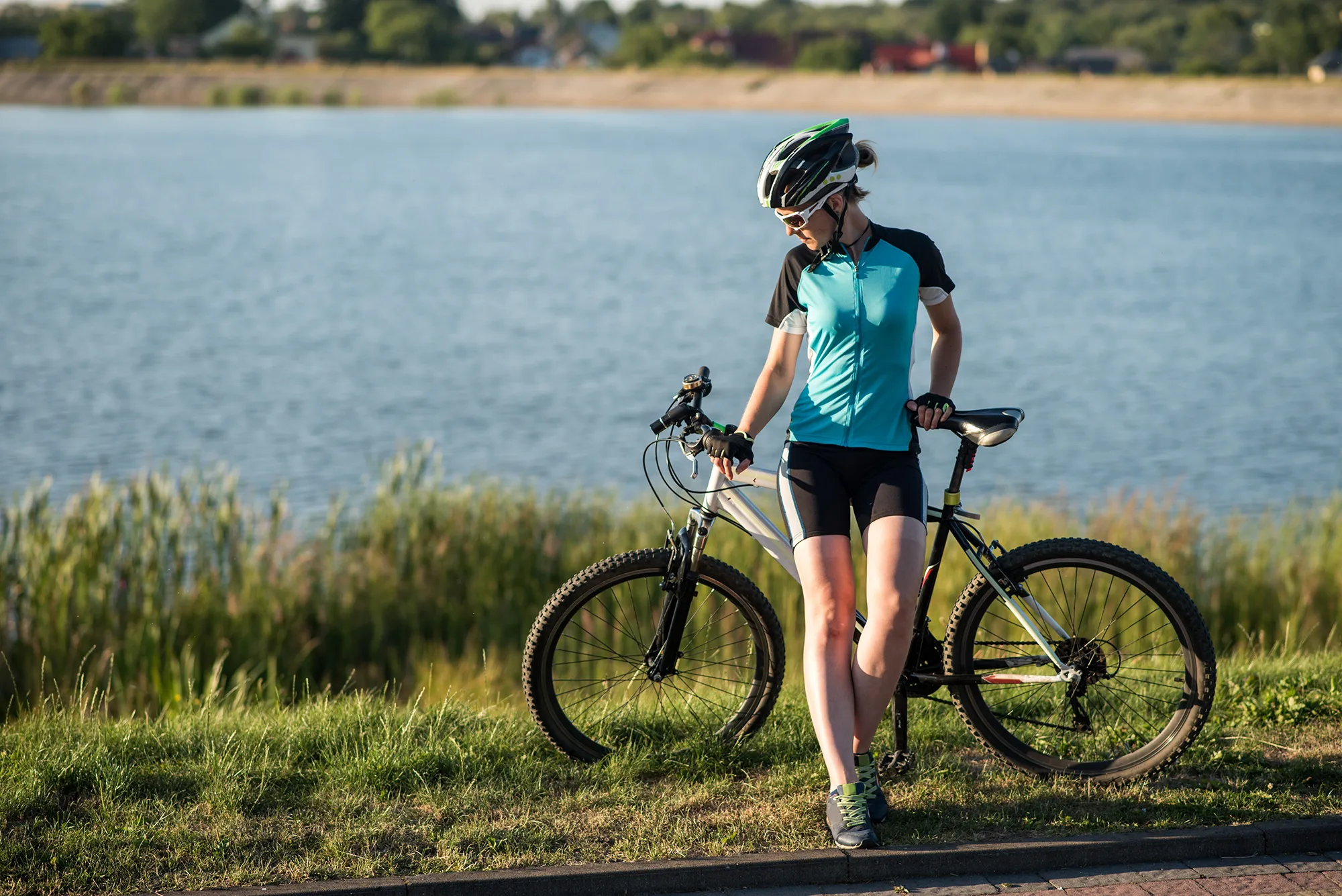 Woman on bike at the lake water background in the park
