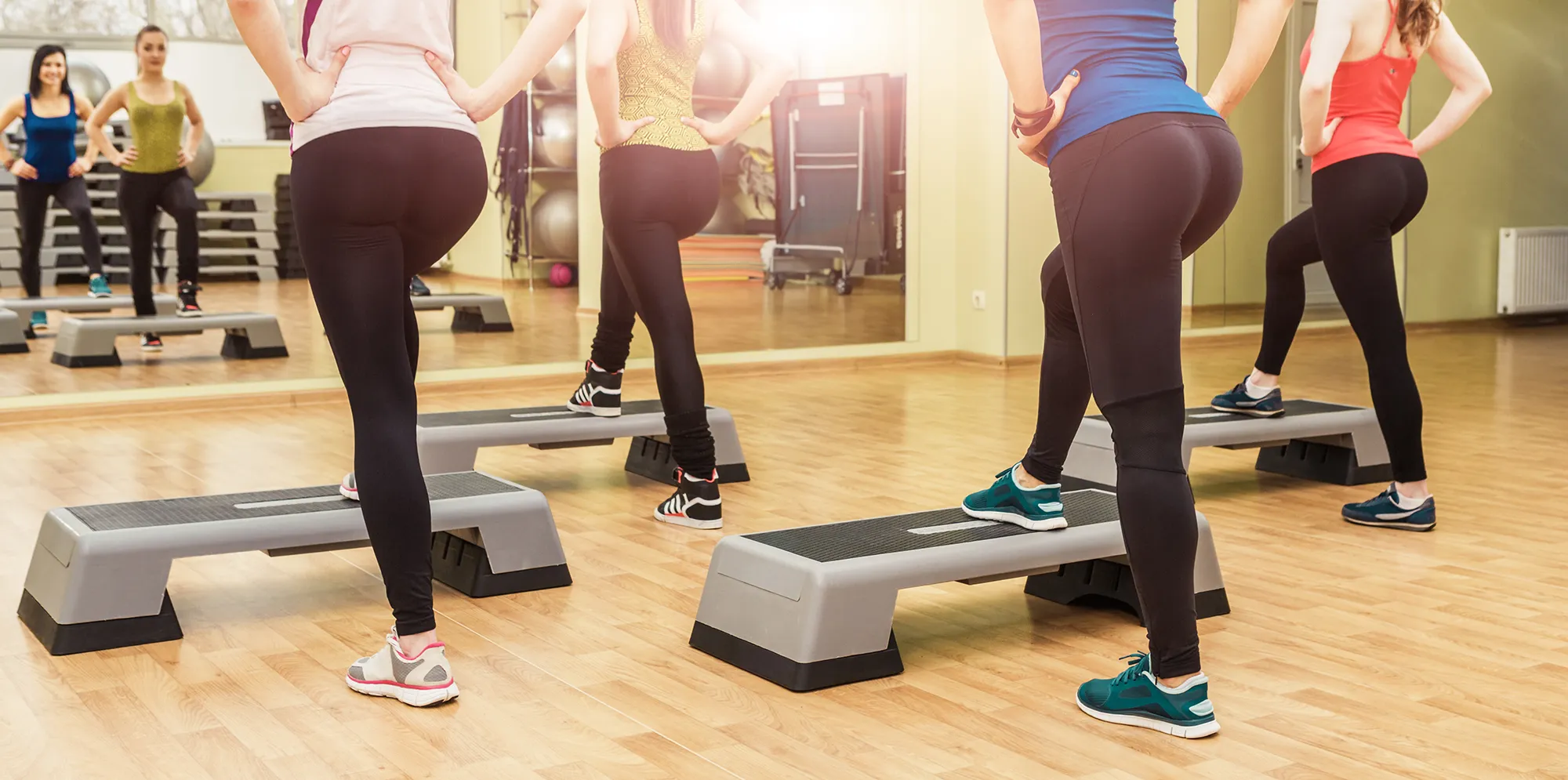 Group of women making step aerobics from the backside
